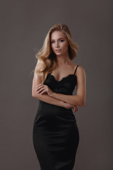 Beautiful woman in black dress in studio