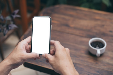 Mockup image blank white screen cell phone.woman hand holding texting using mobile on desk at coffee shop.background empty space for advertise text.people contact marketing business,technology 