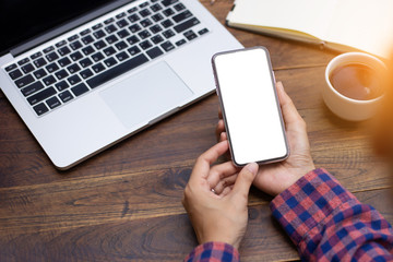 Mockup image blank white screen cell phone.woman hand holding texting using mobile on desk at coffee shop.background empty space for advertise text.people contact marketing business,technology 