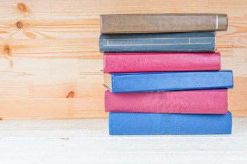 Stack of books on wooden shelf close up