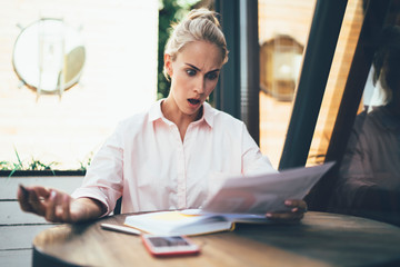 Woman surprised with information in paper document