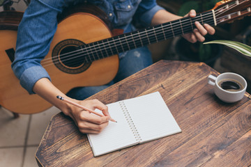 artist songwriter thinking writing notes,lyrics in book at studio.man playing live acoustic guitar relax chill.concept for musician creative.composer work process.people relaxing time with instrument