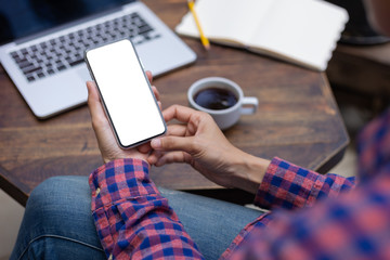 Mockup image blank white screen cell phone.woman hand holding texting using mobile on desk at coffee shop.background empty space for advertise text.people contact marketing business,technology 