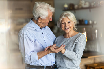 Senior couple dancing together in their home