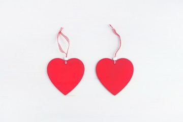 Two heart of love on a ribbon on a white wooden background.Concept of love, romance. Valentine's day postcard.