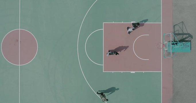 Unmanned top view of people playing basketball on the outdoor basketball court