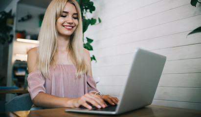 Happy woman working with laptop in cafe