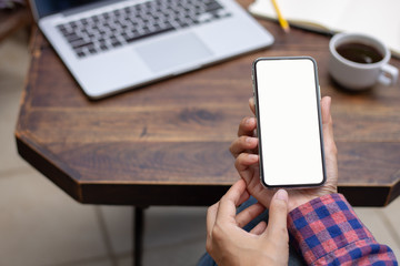 Mockup image blank white screen cell phone.woman hand holding texting using mobile on desk at coffee shop.background empty space for advertise text.people contact marketing business,technology 