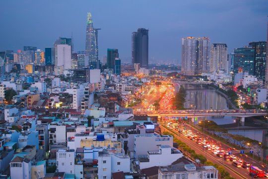 Apartment buildings, modern skyscrapers and broad avenue in Saigon, Vietnam (Ho Chi Minh City). Elevated view at twilight.