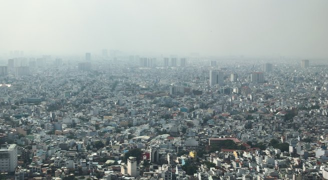 Dense air pollution and smog over Saigon, Vietnam (Ho chi Minh City). Overpopulated city, urban sprawl. Aerial view.