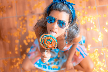 joven mujer posando con golosina dulce azucarado infantil y colorido