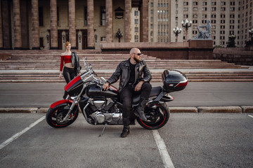 Beautiful couple on a cool motorcycle against Moscow