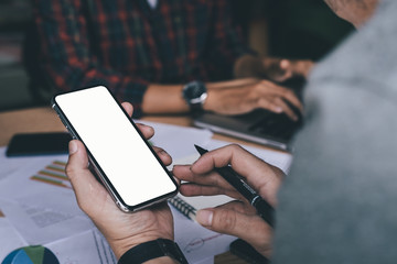 Mockup image blank white screen cell phone.woman hand holding texting using mobile on desk at coffee shop.background empty space for advertise text.people contact marketing business,technology 