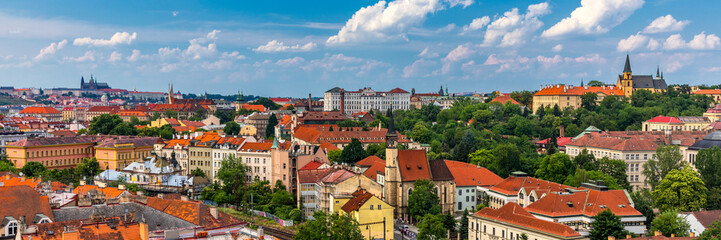 Fototapeta premium View of Prague Castle over red roof from Vysehrad area at sunset lights, Prague, Czech Republic. Scenic view of Prague city, Prague castle and Petrin tower from Vysehrad overlooking red roofs