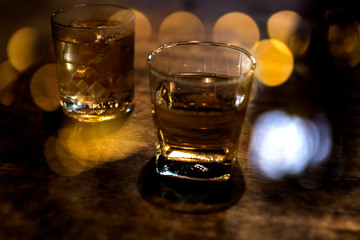 a glass of whiskey on wood bar, soft focus.	