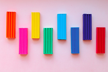 cute flower made of multi-colored plasticine clay on a pink background, multi-colored dough, minimal, children's crafts