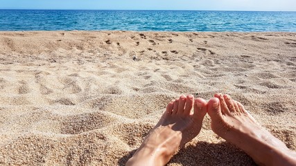 female feet on the beach and sand