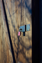 a small red padlock on a wooden door