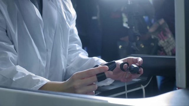 A girl surgeon performs an operation on a patient in virtual reality. Manages the arms of the robotic arms. New technologies in medicine, innovations. Remote treatment of cancer patients and infected.