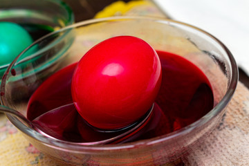 Painting, dying red eggs for Easter in glass jar