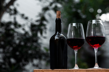 Soft focus red wine in glass on the bar, and hands of a bartender at bar with glass whiskey drink,	