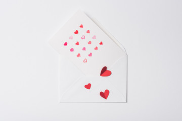 top view of valentines greeting card in envelope with red hearts on white background