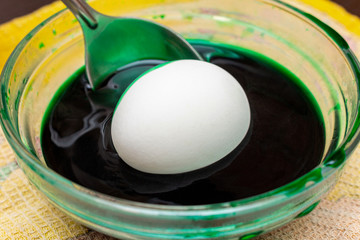 Painting, dying green eggs for Easter in glass jar