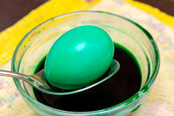 Painting, dying green eggs for Easter in glass jar