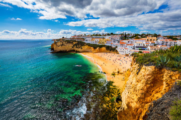 View of Carvoeiro fishing village with beautiful beach, Algarve, Portugal. View of beach in Carvoeiro town with colorful houses on coast of Portugal. The village Carvoeiro in the Algarve Portugal.