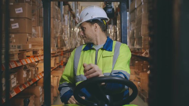 Huge distribution warehouse with high shelves and forklift with operator.