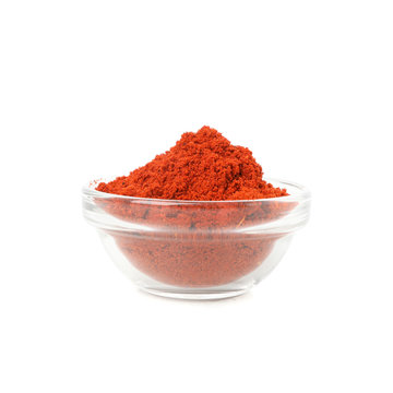 Glass bowl with red pepper powder isolated on white