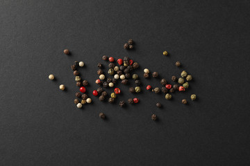 Pepper spice on black background, top view and space for text
