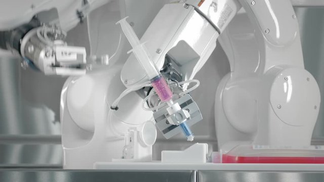 Robotic arm makes an injection with chemotherapy medicine. Two manipulators fills the drug into a syringe. New technologies in medicine, innovations. Remote treatment of cancer patients and infected.