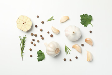 Flat lay of composition, garlic bulbs, slices, spice, parsley, rosemary on white background, top view. Space for text