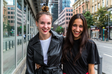 Portrait of Two Young Women Smiling Side by Side on City Street