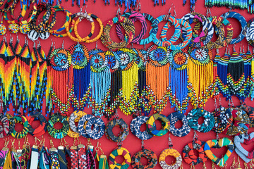 Tribal masai colorful earrings for sale for tourists at the beach market, close up. Island of Zanzibar, Tanzania, Africa