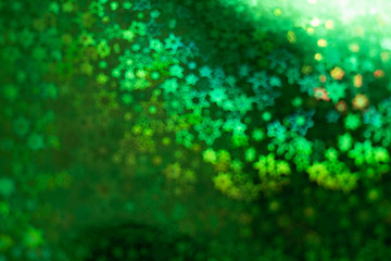 Holographic  green background with abstract colorful blur stars shaped bokeh
