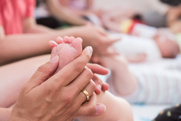 Eine Frau massiert den Fuß eines Babys