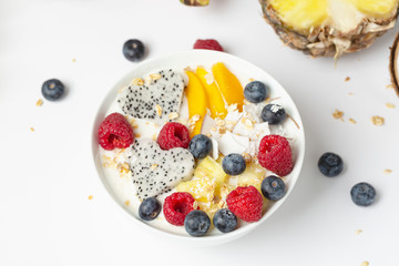 Smoothie bowl with mango, pineapple, dragon fruit, blueberries, raspberries and coconut. Delicious and healthy Breakfast.