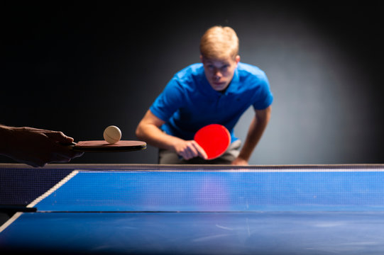 Table tennis ping pong paddles and white ball on blue board