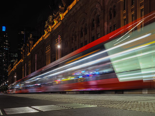 Motion blurred of Sydney tram public transport inside city center at night time.
