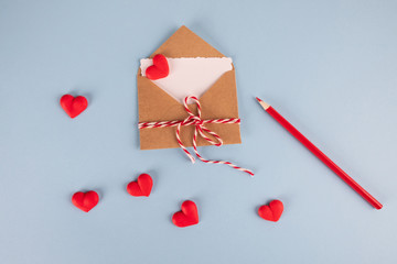 Valentine's day love letter mockup. Craft envelope with white blank card and hearts on blue background. Top view Flat lay . Valentines day, Mothers day, Womens day greeting card.