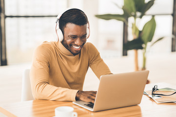 Smiling african american businessman chatting online at work