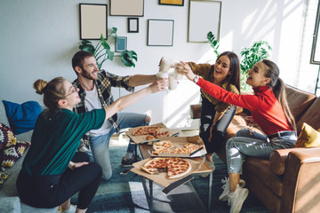 Trendy coworkers having pizza party in office