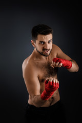 Fototapeta na wymiar Sportsman boxer throwing a fierce and powerful punch. muscular man on black background.