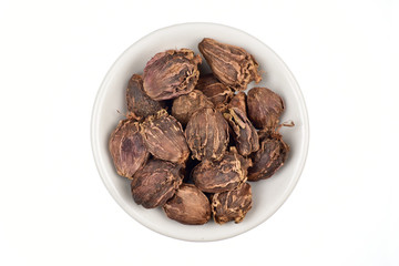 Black cardamom in bowl isolated on white background with clipping path