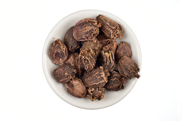 black cardamon or badi elaichi in white bowl over white background, top view