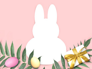 Mock up Easter composition with bunny template frame, multicolor eggs, palm leaves on pink background. Greeting holiday concept with copyspace.