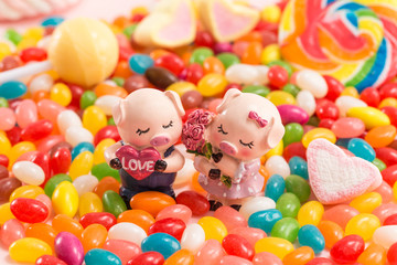 Fototapeta na wymiar A pair of piggy dolls in many candies