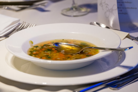  Older Woman Eating Soup At A Restaurant Setting